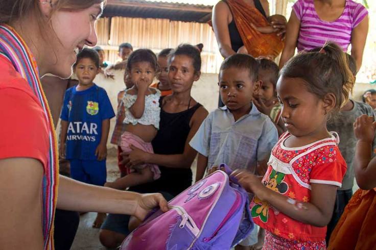 Eliza handing out schoolbags and toothbrushes